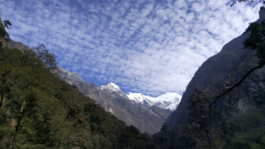 Majestic mountainous landscape with snow peaks under a stratified sky.