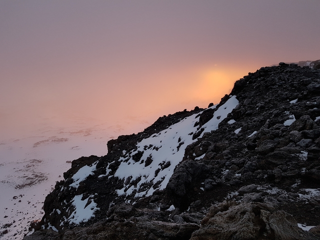 Rocky, snowy terrain at sunrise.