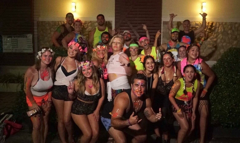Group of people at a party with neon face paint and costumes.