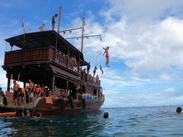 People on a boat jumping into the sea.