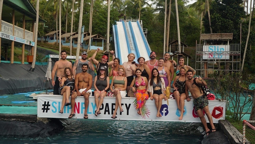 Large group posing in front of water slides at a water park.