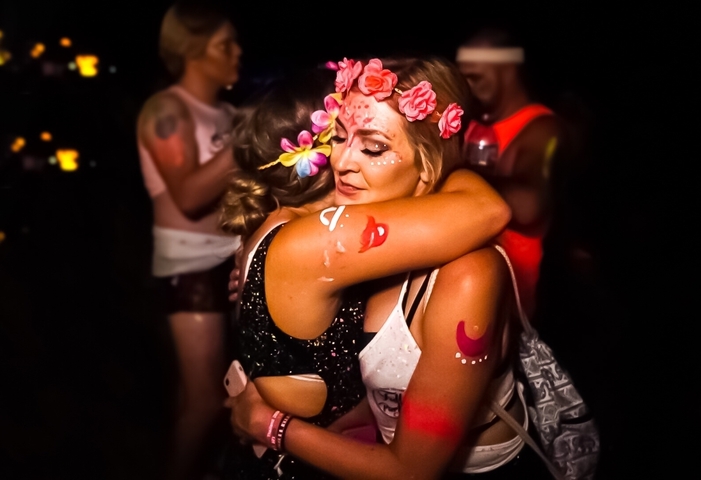 Close-up of two women embracing at a night event.