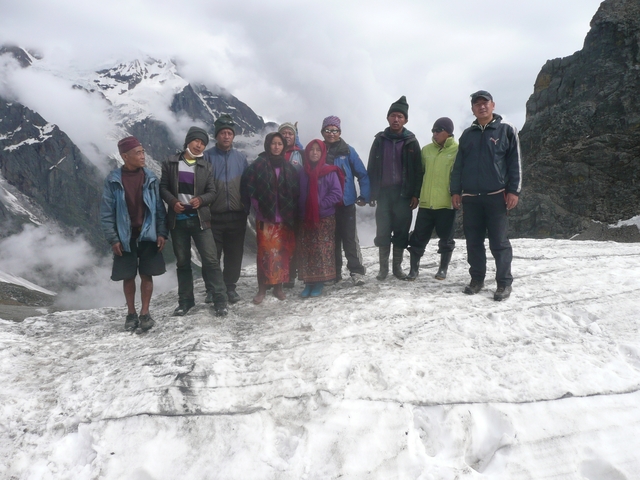 A group of people standing on a snowy landscape with mountains in the background.