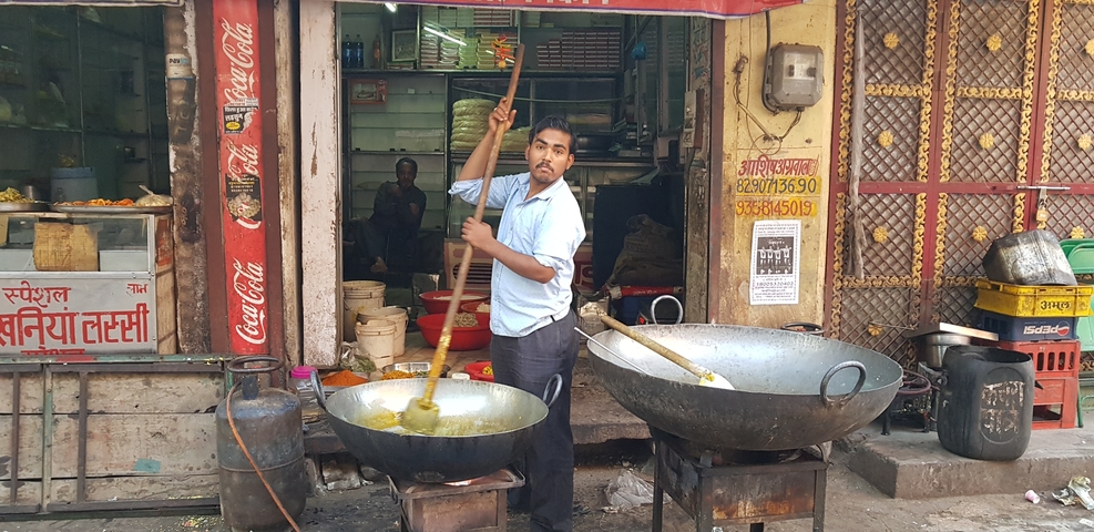 Man cooking in large pots on a street-side.