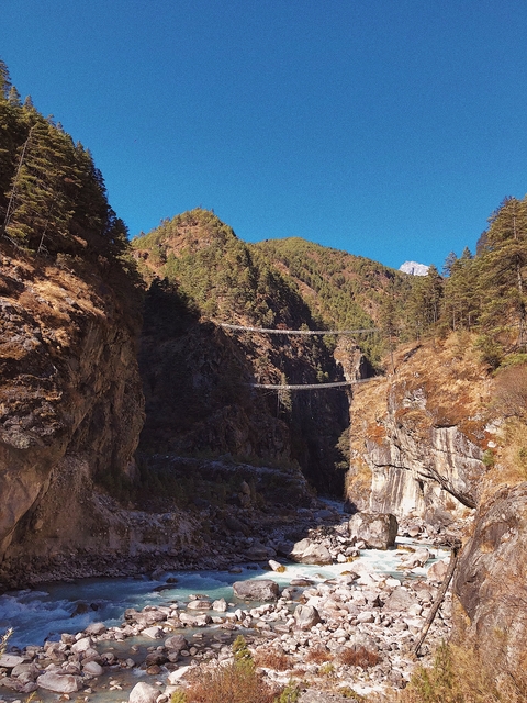 View of deep valley with suspension bridges crossing.