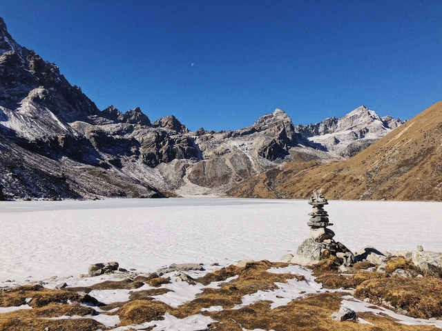 Snow-covered alpine landscape with rocky peaks and clear skies.