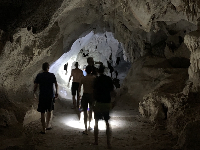 People exploring a cave with a flashlight.