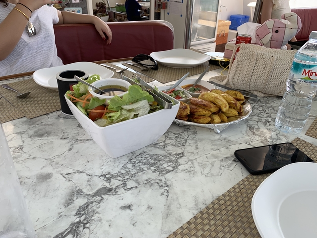 Outdoor meal setting with salad and fried plantains.