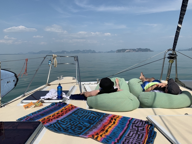 People relaxing on a boat with a scenic ocean view.