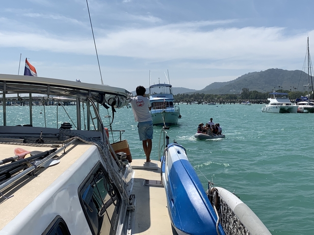 Boats at sea with mountains in the background.