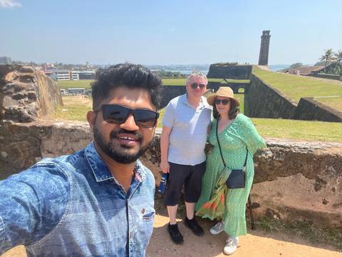 A group selfie at a historical fort with an ocean view.