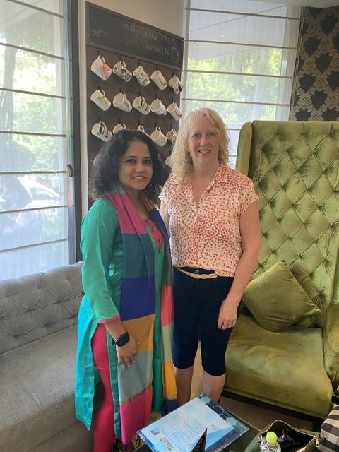 Two women posing in a cafe.