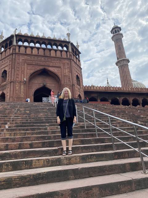 Woman posing on steps of a historic site.