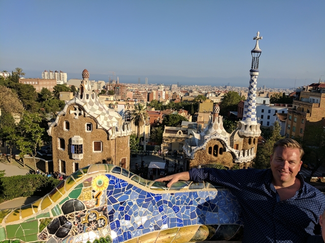 View of Park Güell with unique architectural features and a person enjoying the view.