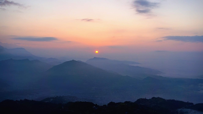 A beautiful view of mountains during sunset with layered silhouettes.