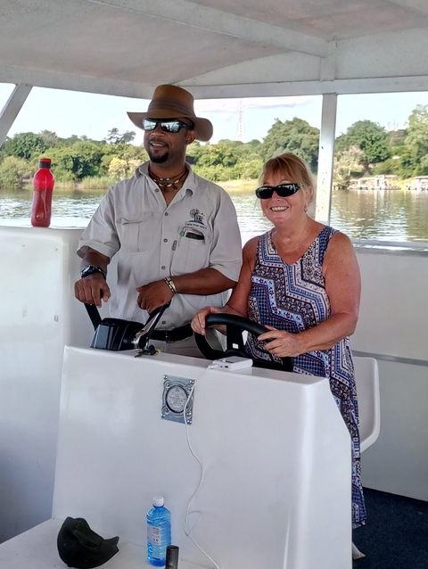 Two people posing on a boat, the woman is smiling.