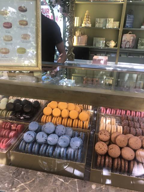 A display of colorful macarons in a patisserie.