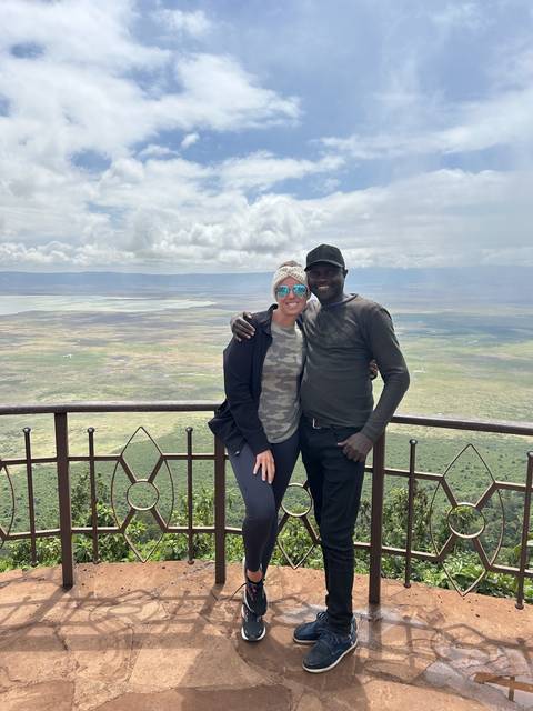 Couple posing at a viewpoint overlooking a landscape.