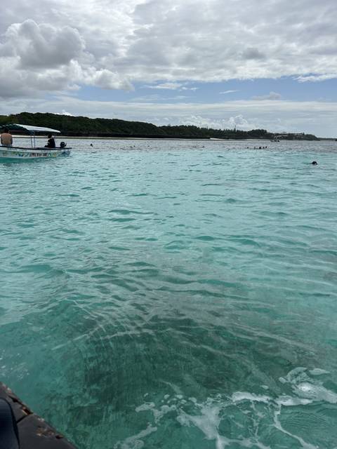 Clear ocean water with a small boat.