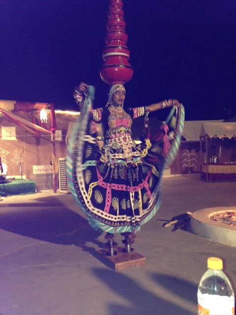 A woman in traditional dress performing a dance at night.
