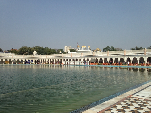 A large pool area surrounded by a grand building with domes.
