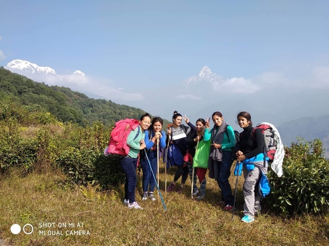 Group of hikers posing with mountain landscape in the background.