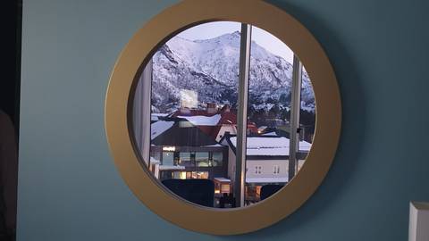 Mountain view through a round window.