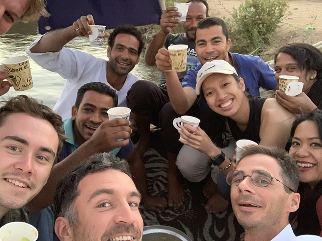 Group of people having a cheerful gathering, raising cups.