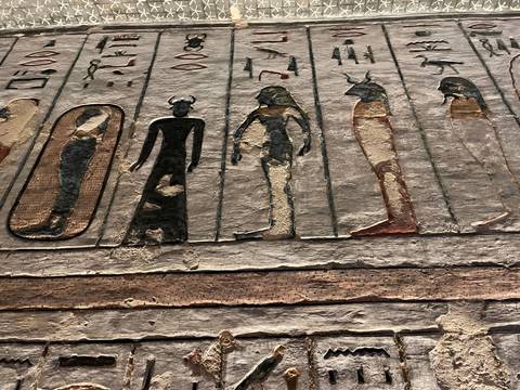 Ancient Egyptian wall carvings with figures and symbols.