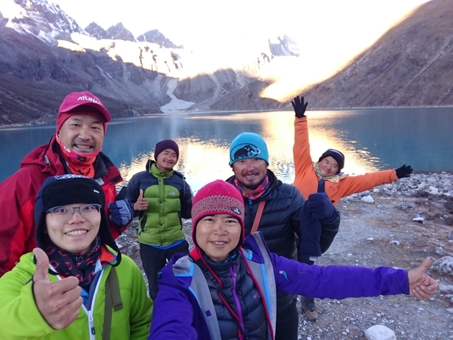 Group of hikers posing near a lake in the mountains.