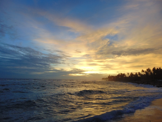 Sunset over the ocean with a colorful sky.
