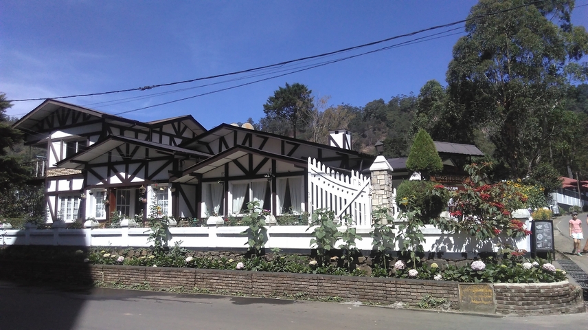 A colonial-style building with a picket fence.