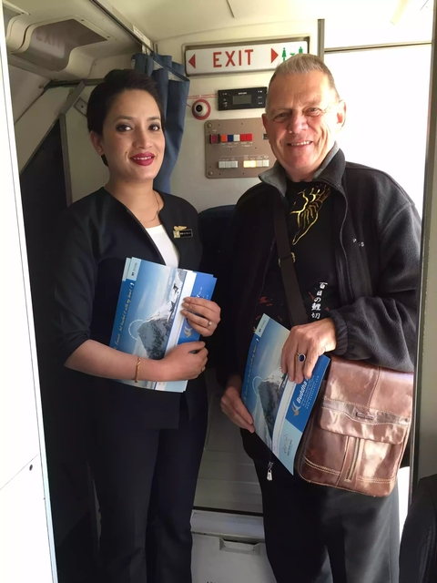 Two individuals holding Nepal Airlines promotional material.