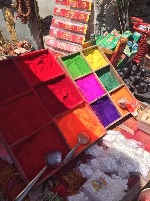 Brightly colored powders displayed for sale.