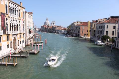 View of Grand Canal in Venice with a boat moving through.