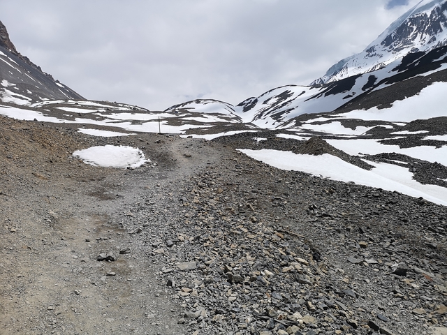 Mountain path covered with snow and rocks
