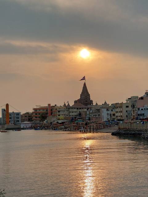 A sunset over a riverside with a historic temple silhouette.