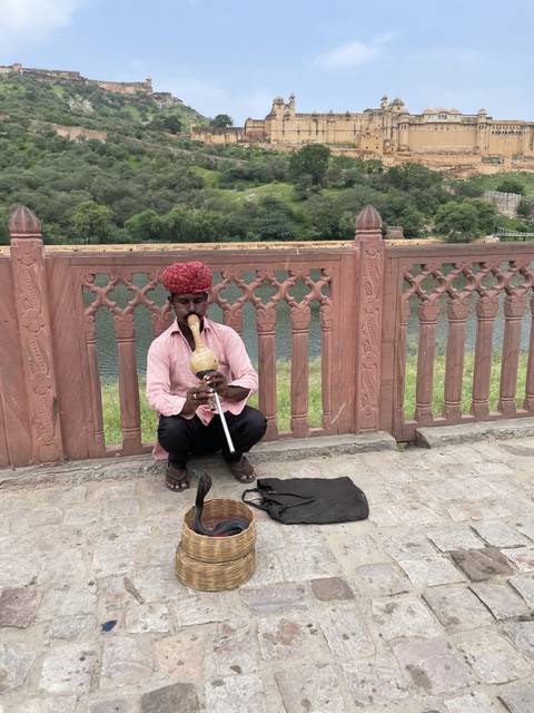 A person playing a traditional instrument on a bridge.