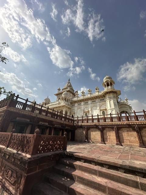 White marble building with ornate carvings and domes.
