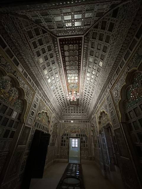 Room with mirrored walls and intricate decorations.