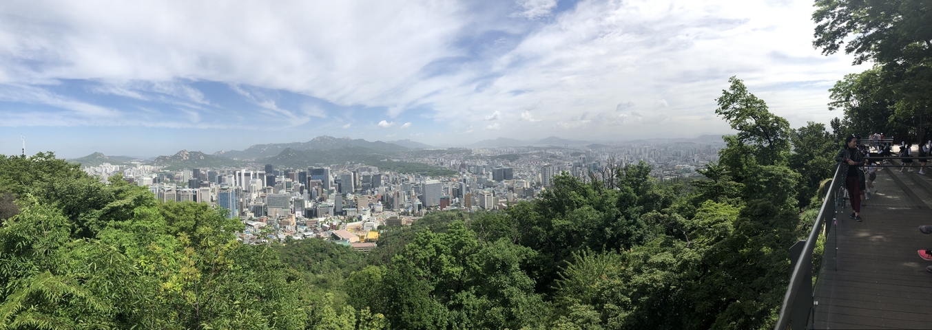 Panoramic view of a city skyline with surrounding hills.