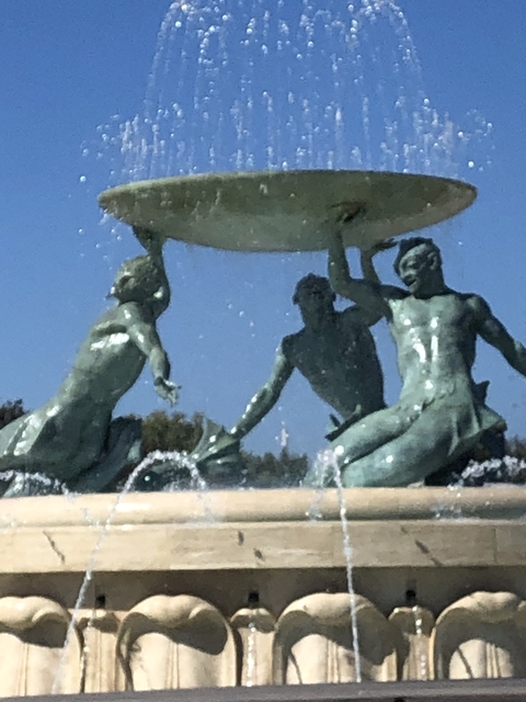Close-up of a fountain with statues of figures holding a basin.