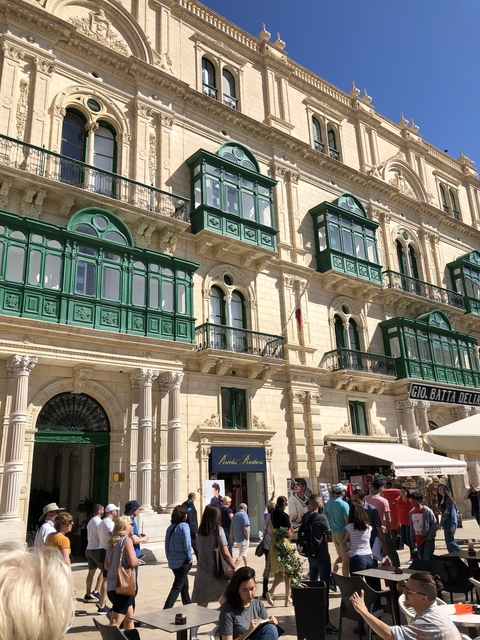 Detailed facade of a historic building with green balconies.