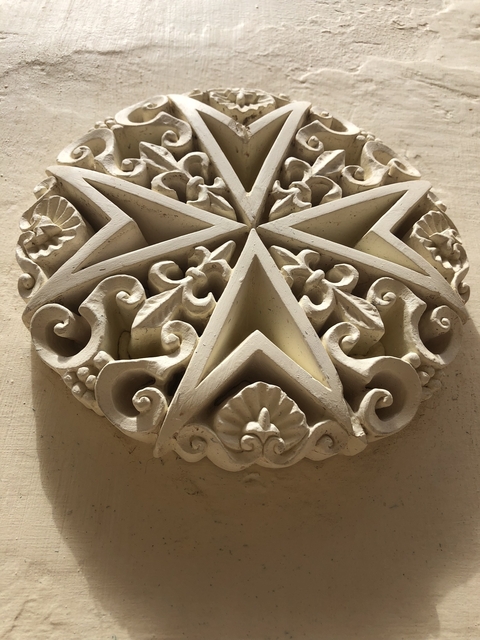 Close-up of a carved stone ornament featuring a star and floral motifs.