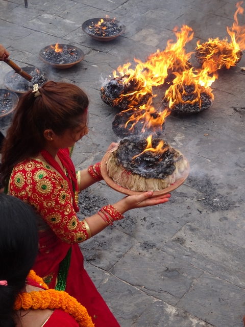 Woman holding a flaming ritual bowl.