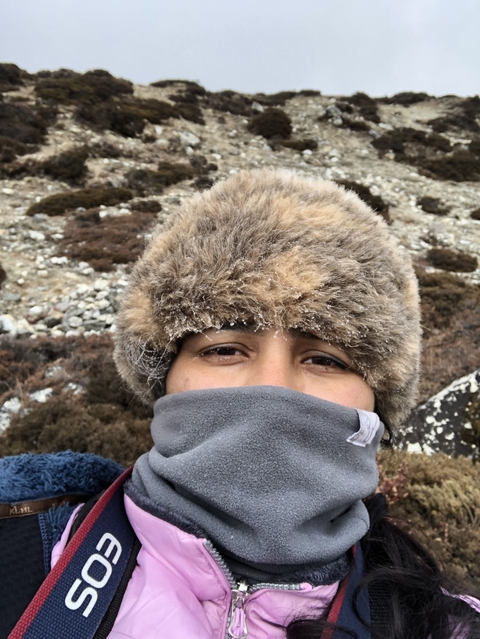 Close-up of a person wearing winter gear in a rocky terrain.
