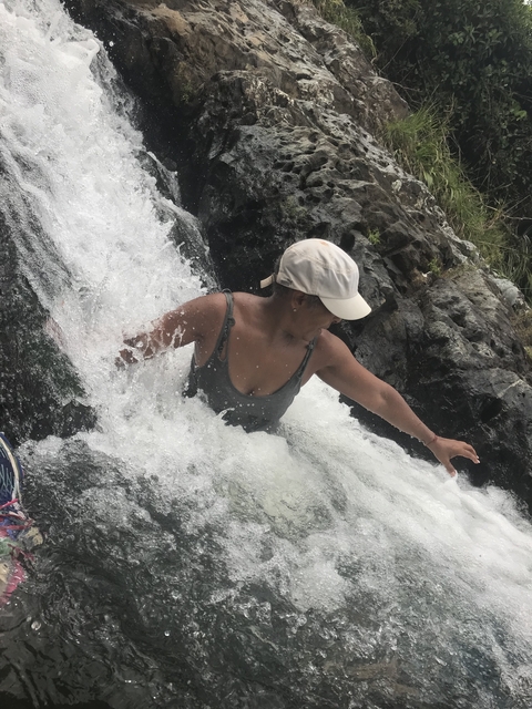 Woman enjoying water falling on her.