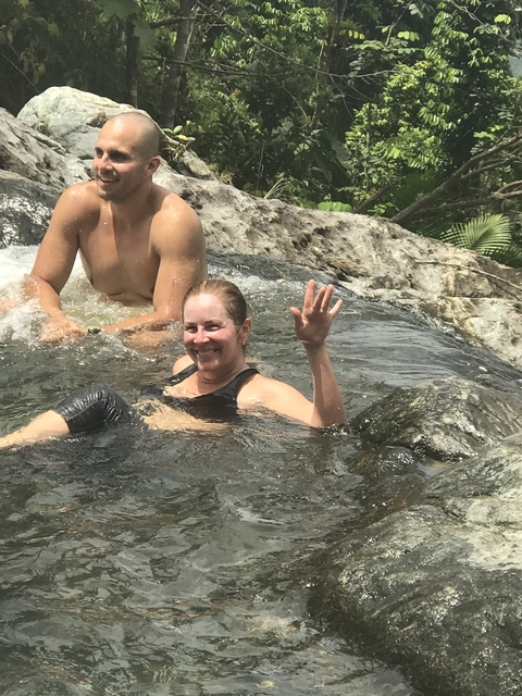 Person wading in water at a rocky spot.