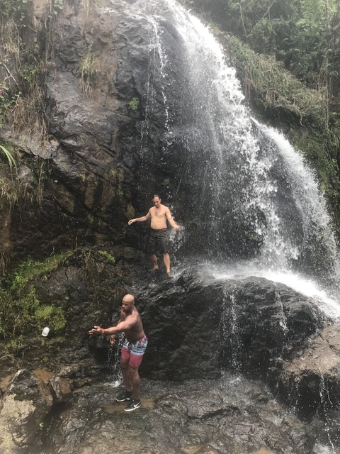 Man standing under a waterfall.