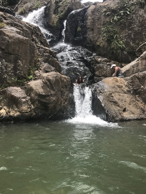 Two women exploring a waterfall setting.
